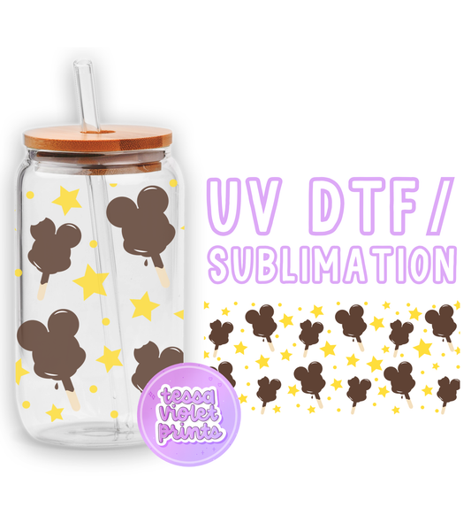 a glass cup with a straw lid and a mickey mouse design on it